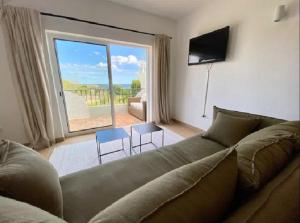 uma sala de estar com um sofá e uma grande janela em Serenity T3, 2 terraces seaview 600m beach na Praia da Luz