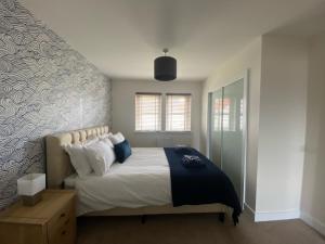 a bedroom with a bed with blue and white pillows at The Lookout in Cellardyke