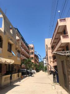 a city street with tall buildings on a sunny day at Hyven's Apartments in Mtwapa