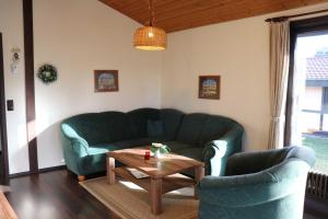 a living room with a green couch and a coffee table at Ferienhaus Robinson Schinderhanneseck 112 in Waldbrunn