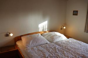 1 cama en un dormitorio con 2 almohadas en Ferienhaus Robinson Schinderhanneseck 112, en Waldbrunn