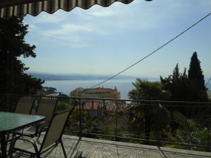 a balcony with a table and chairs and a view of the water at Apartment Ella, Opatija in Opatija