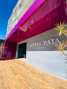 a building with a sign on the side of it at Hotel Zata e Flats in Criciúma