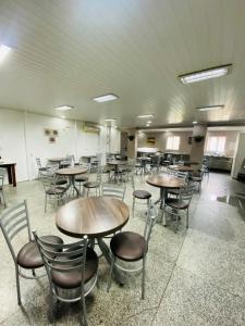 a room with tables and chairs in a classroom at Hotel Zata e Flats in Criciúma