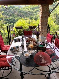 uma mesa de vidro com comida em cima de uma varanda em L'EMBELLIE em Thueyts