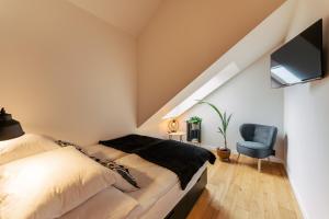 een slaapkamer met een bed en een blauwe stoel bij Apartament BLACK OAK SurfingBird Dźwirzyno in Dźwirzyno