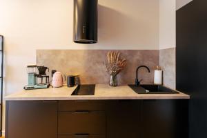a kitchen with a sink and a counter top at Apartament BLACK OAK SurfingBird Dźwirzyno in Dźwirzyno