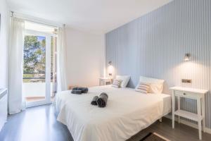 - une chambre blanche dotée d'un grand lit avec des chaussures dans l'établissement Lord Jim Pinewalk Apartment, à Port de Pollença