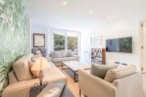 un salon avec deux canapés et une télévision dans l'établissement Lord Jim Pinewalk Apartment, à Port de Pollença