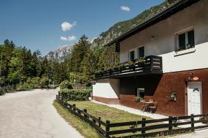 ein Gebäude mit einem Zaun neben einer Straße in der Unterkunft Nature Lover's Paradise in Julian Alps in Mojstrana