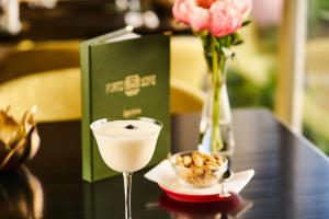 Hotel Porto Sofie Gottlieben في غوتليبن: مشروب ووعاء من المكسرات على طاولة