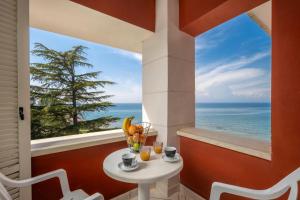 Zimmer mit einem Tisch und Meerblick in der Unterkunft Villa Valdepian Apartments in Savudrija