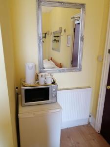 a mirror on top of a microwave in a bathroom at The West Pier Residence in Brighton & Hove