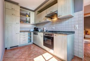a kitchen with white cabinets and an oven at Gartenoase Ahlbeck -01 in Ahlbeck