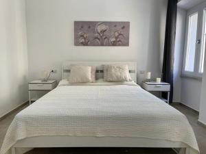 a bedroom with a large white bed with two tables at Matty's in Olbia