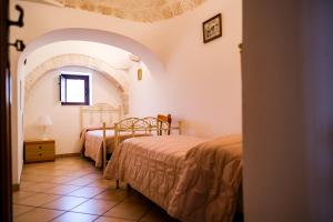 a bedroom with two beds and a window at TRULLO ELVIRA & LUIGI in Monopoli