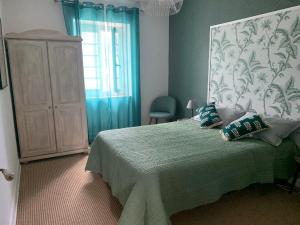 ein Schlafzimmer mit einem Bett, einer Kommode und einem Fenster in der Unterkunft gîte La Longère bleue in Caylus