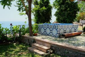 une grande baignoire bleue et blanche assise sur un mur en pierre dans l'établissement Casa Paradiso, à Terracine