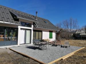 dom ze stołem i krzesłami przed nim w obiekcie Maison dans parc clôturé w mieście Barcelonnette