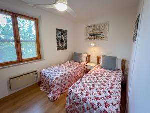 um quarto com 2 camas e uma janela em casa vacanze la palma em Marina di Campo