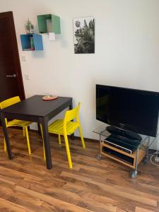 a living room with a table and a television at Ferienwohnung Mazur in Murnau am Staffelsee