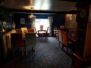 a dining room with tables and chairs and a clock at The Blue Cow in South Witham