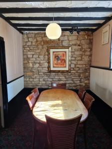 a dining room with a wooden table and chairs at The Blue Cow in South Witham