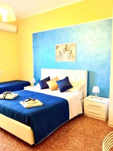 a bedroom with a bed with blue and yellow walls at La Città degli Dei in Agrigento