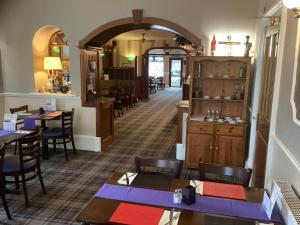 a restaurant with tables and chairs in a room at Edenbank Hotel in Dumfries