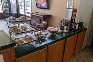 a counter with a bunch of pastries on it at Atrium Inn in Fort Stockton