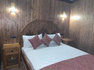 1 dormitorio con 1 cama blanca y paredes de madera en Riad Palais Marouane en Meknès