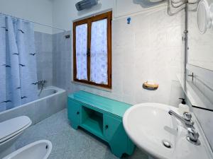 マリーナ・ディ・カンポにあるcasa vacanze la palmaの洗面台、トイレ、窓のあるバスルーム