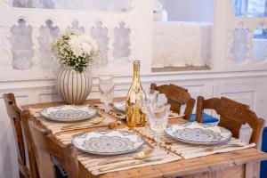 a wooden table with plates and a bottle of champagne at Nisos Villa Olympos Karpathou in Olympos