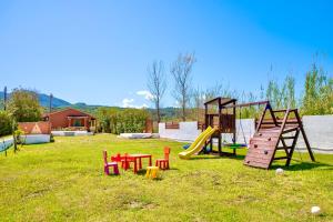 a playground with colorful play equipment in a yard at Villa Yiannitsis-Harmony In The Flowers, Acharavi Beach in (( Litherés ))