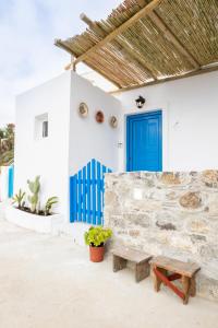 a blue door and a bench in front of a building at Nisos Villa Olympos Karpathou in Olympos