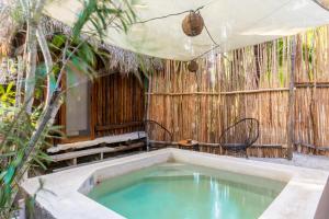an outdoor bath tub in a room with a fence at Eco Cabañas Laak Holbox - Adults Only - Self Check In in Holbox Island