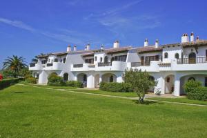 a large white house with a green lawn at Cheap & Chic Apartamentos en Son Bou de 2 dormitorios in Son Bou