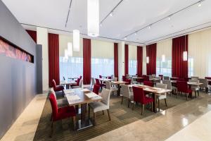 a restaurant with wooden tables and red chairs at Lagoas Park Hotel in Oeiras