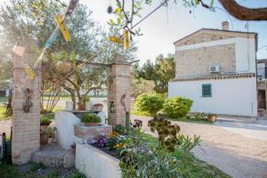 a garden with flowers and a building in the background at Masseria Piana Cimino in Pietra Montecorvino