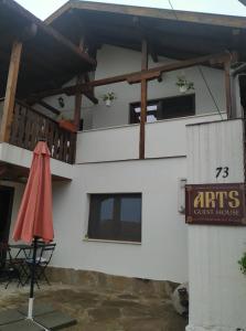 un edificio blanco con una señal y una sombrilla en Arts Guest House -Beautiful villa for 6 persons, en Veliko Tŭrnovo