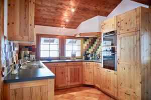 a large kitchen with wooden cabinets and a sink at Roux in Grimentz