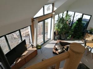 a living room with large windows and a couch at Maison dans parc clôturé in Barcelonnette