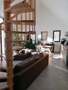 a living room with a couch and a wooden spiral staircase at Maison dans parc clôturé in Barcelonnette