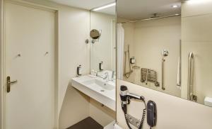 a bathroom with a sink, mirror, and bath tub at Sercotel Hotel Rosellon in Barcelona