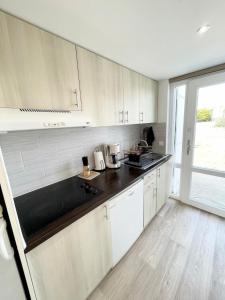 uma cozinha com armários brancos e um balcão preto em Maisonnette de charme - Refaite à neuf - Vue mer em Guidel