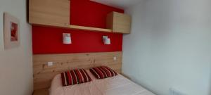 Un dormitorio con una pared de acento rojo y una cama en Apt With Garden In La Plagne, en La Plagne
