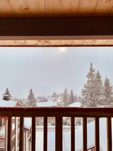 un balcón con vistas a un patio cubierto de nieve en Font -Romeu : Beau T4 avec parking, terrasse et vue, en Font-Romeu-Odeillo-Via