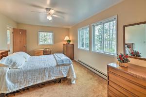 a bedroom with a bed and a dresser and windows at Lakefront Broadalbin Getaway with Deck and Kayaks in Broadalbin