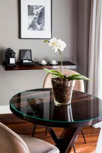 una mesa de cristal con una flor en un jarrón. en CasaSur Recoleta en Buenos Aires