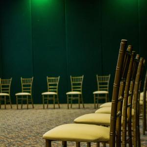 a row of chairs in a room with a green wall at Hotel Hacienda Cola del Caballo in Santiago